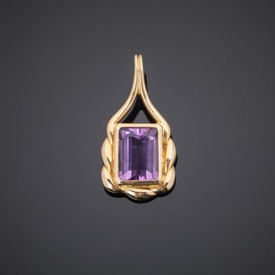 a gold pendant with an amethorate stone in the center