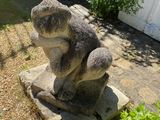 une statue représentant un ours assis sur un bloc de pierre