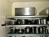 many pots and pans on the shelves in the kitchen