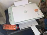 a printer sitting on top of a desk next to a pile of clutter