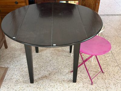 une table noire et deux tabourets roses dans une pièce