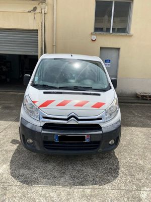 La petite camionnette est garée devant un garage.