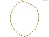 gros plan d'un collier en or sur fond blanc
