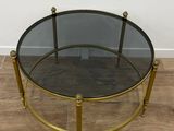 une table basse en verre et laiton avec un plateau rond en verre