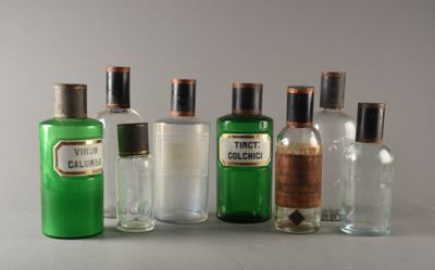 cinq bouteilles d'alcools de différentes sortes posées sur une table