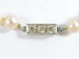 pearl and diamond necklace on a white background with a silver clasp