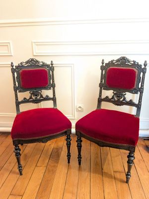 pair of red upholstered chairs on wooden floor in room