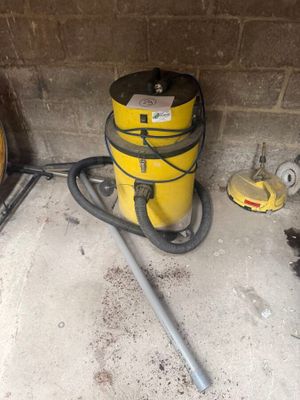 un aspirateur jaune et noir posé par terre à côté d'un seau jaune