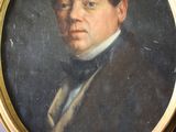 tableau représentant un homme en costume et nœud papillon, dans un cadre doré