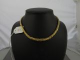 a gold necklace on a black mannequin with a price tag on it