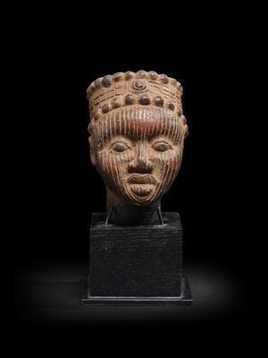 un gros plan d'une sculpture représentant une tête sur une surface noire