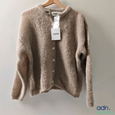 a close up of a sweater hanging on a hanger on a wall
