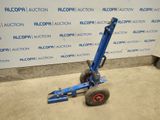 an image of a blue hand truck parked in front of a wall