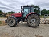 a red tractor that is parked in the dirt