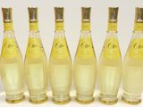 six bouteilles de limonade sont alignées sur une surface blanche