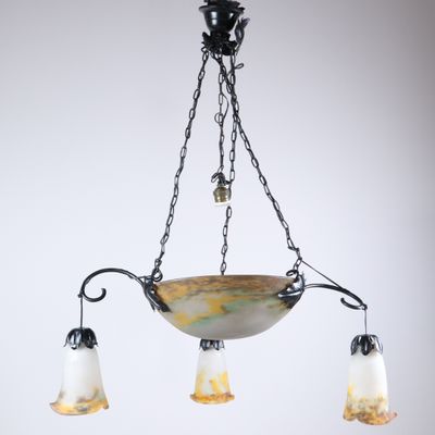 un lustre composé de trois abat-jours en verre suspendus à une chaîne
