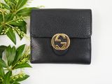 a small black leather wallet with a gold gg logo on the front