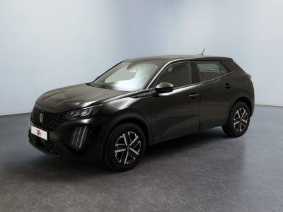un SUV noir garé dans une pièce aux murs blancs