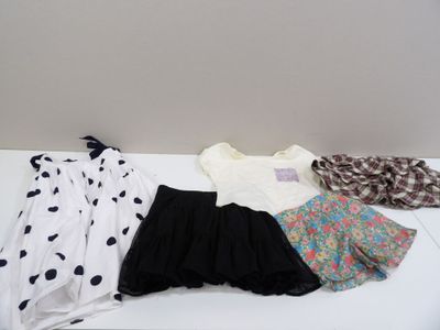 trois robes et un foulard posés sur une table
