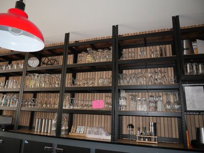 a red light hanging over a shelf filled with wine glasses