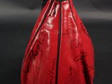 a red bag with writing on it sitting on a black surface