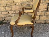 an old fashioned chair sitting in front of a brick wall