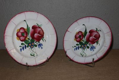 deux assiettes avec des fleurs peintes dessus, posées sur une table