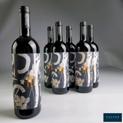 trois bouteilles de vin ornées d'un motif, posées sur une table