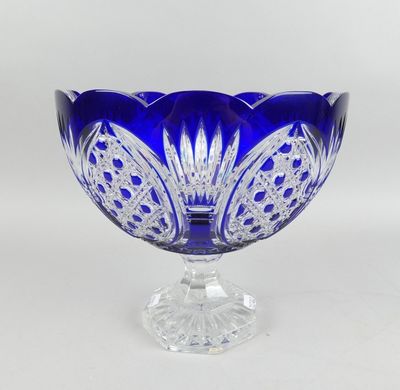 un gros plan d'un bol en verre bleu posé sur un socle transparent