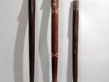 three baseball bats that are sitting on a white surface