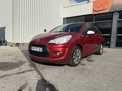 La petite voiture rouge est garée devant un immeuble.