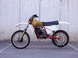 a dirt bike parked in a parking lot next to a wall
