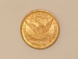 a close up of a gold coin on a white surface