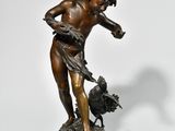 statue en bronze représentant un garçon avec un oiseau, posée sur un socle en marbre