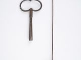 a small metal object with a long handle next to a small metal object