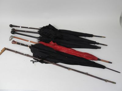 several umbrellas are lined up on a white surface with a clock in the background