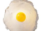 a fried egg on top of a piece of cake