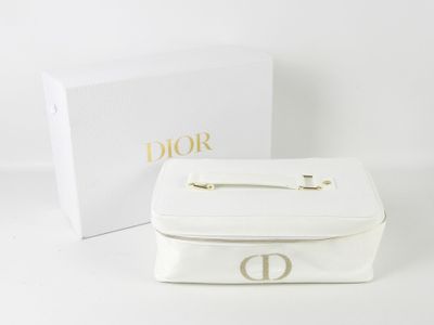 une boîte blanche avec un logo doré, à côté d'une autre boîte blanche