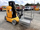 a small yellow lift truck parked in a parking lot