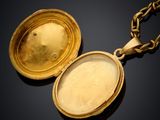 two gold lockes on a chain on a black surface