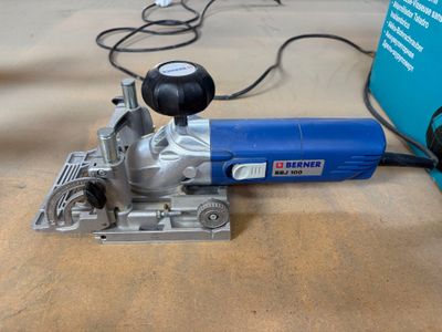 une ponceuse électrique bleue et argent posée sur une table