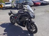 a black motorcycle parked in a parking lot next to a truck