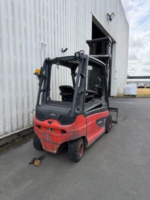 a red forklift truck parked in front of a building