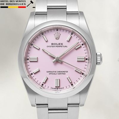 un gros plan d'une montre au cadran rose montée sur un bracelet