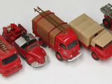 de nombreux camions de pompiers rouges miniatures alignés sur une surface blanche