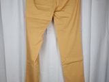 a pair of yellow pants hanging on a hanger in front of a white curtain