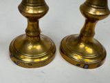 pair of antique brass candlesticks on a white background
