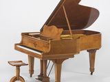 un piano à queue avec un tabouret devant