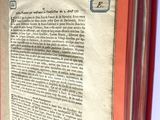 un livre ouvert, à la couverture rouge, posé sur une table