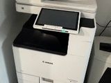 une imprimante blanche posée sur une imprimante noir et blanc